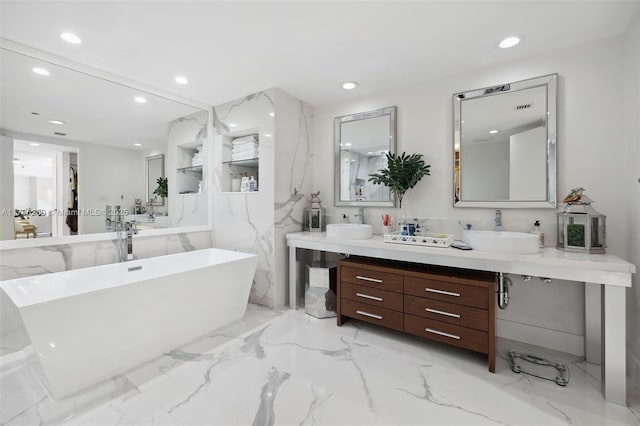 bathroom with a freestanding tub, vanity, recessed lighting, and marble finish floor