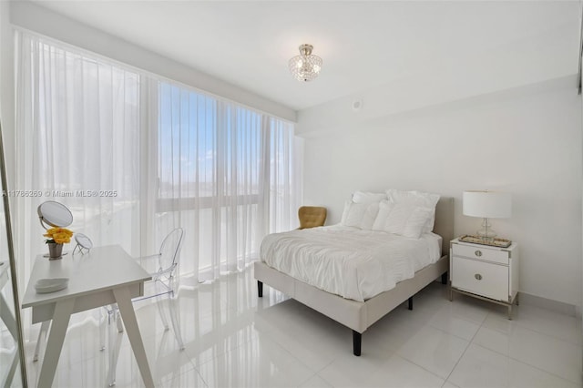 bedroom featuring light tile patterned flooring and baseboards