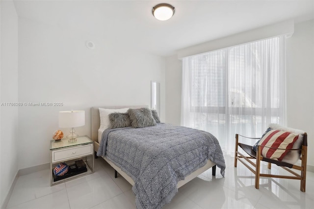 bedroom with baseboards, multiple windows, and light tile patterned floors