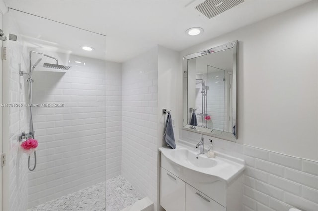 full bathroom with vanity, recessed lighting, visible vents, and tiled shower