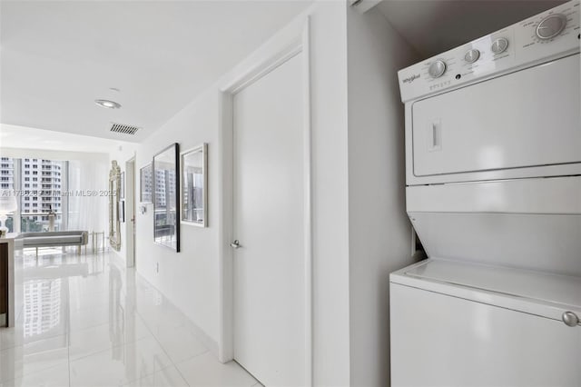 washroom with visible vents, stacked washer / drying machine, light tile patterned floors, baseboards, and recessed lighting