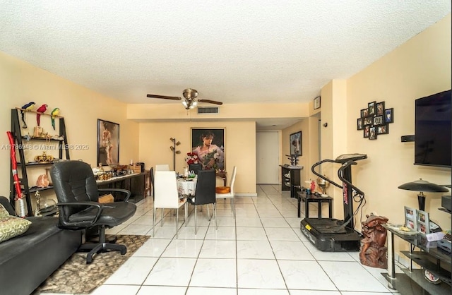living area featuring a ceiling fan, a textured ceiling, visible vents, and light tile patterned floors