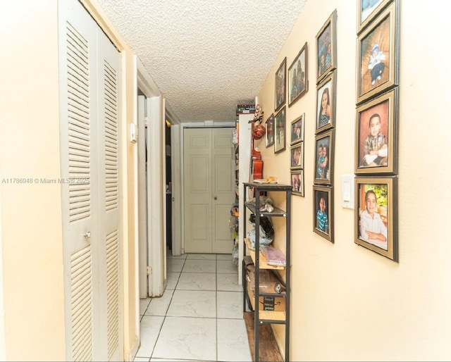 hall featuring a textured ceiling and marble finish floor