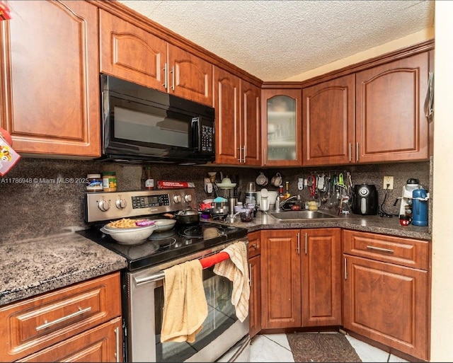 kitchen with black microwave, backsplash, a sink, and stainless steel range with electric stovetop