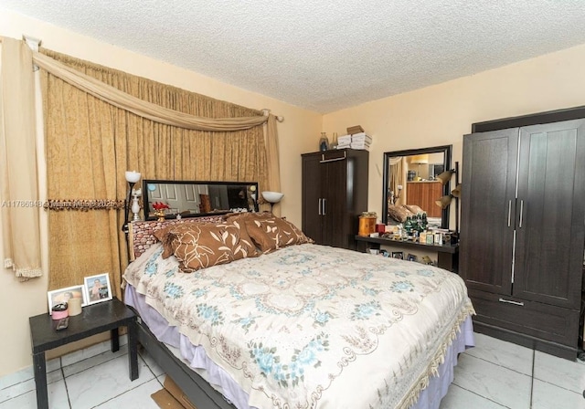 bedroom featuring a textured ceiling and marble finish floor