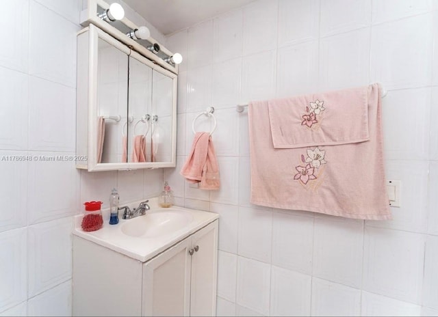 bathroom with vanity and tile walls
