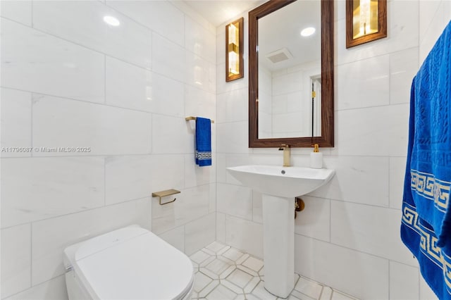 bathroom featuring toilet, tile walls, recessed lighting, and visible vents
