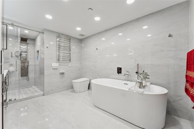 full bathroom featuring tile walls, a soaking tub, a stall shower, and marble finish floor