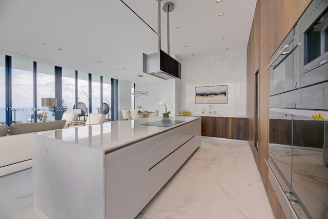 kitchen featuring brown cabinetry, marble finish floor, modern cabinets, and a spacious island