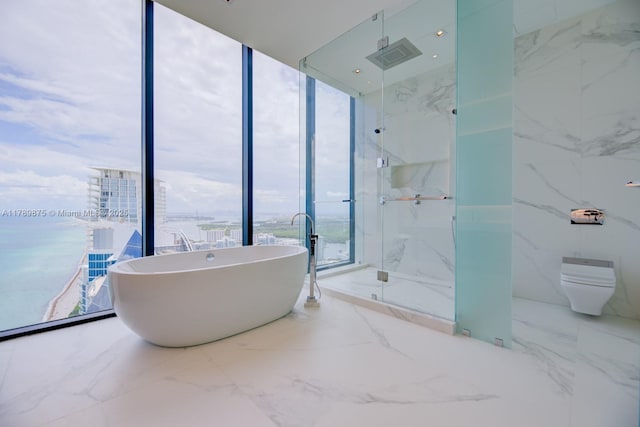 bathroom with a water view, a soaking tub, a marble finish shower, and marble finish floor