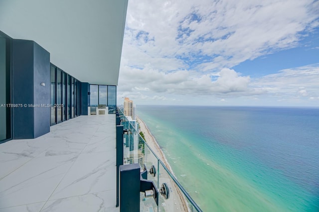 balcony with a water view and a beach view