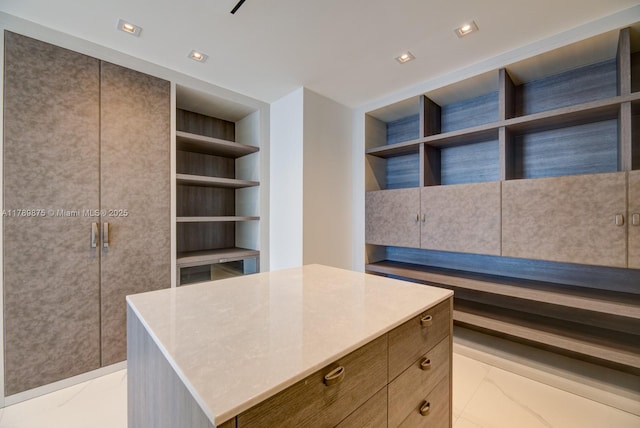walk in closet featuring marble finish floor