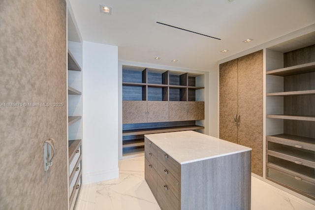 spacious closet featuring marble finish floor