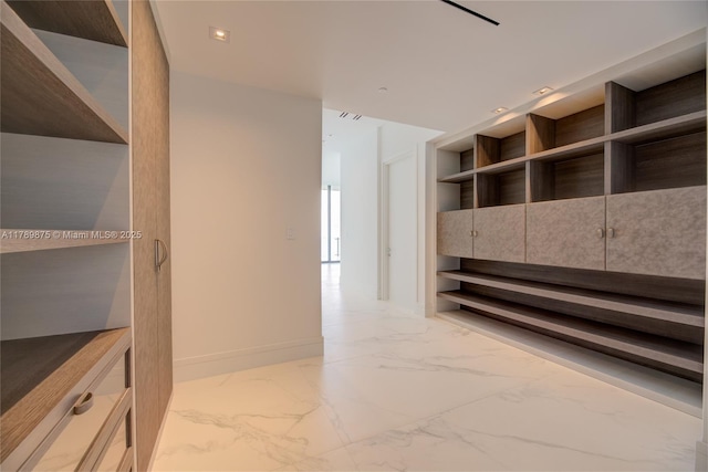 walk in closet with marble finish floor
