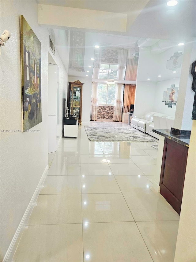 corridor with visible vents, baseboards, and light tile patterned floors