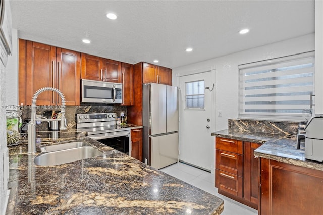 301 NE 14th Ave Unit 207, Hallandale Beach, FL 33009 - kitchen featuring stainless steel appliances, a sink, dark stone counters, recessed lighting, and decorative backsplash