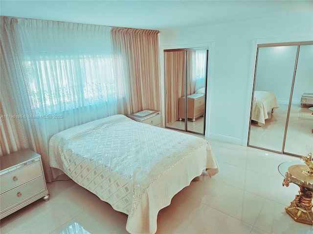 bedroom featuring multiple closets, multiple windows, and tile patterned flooring