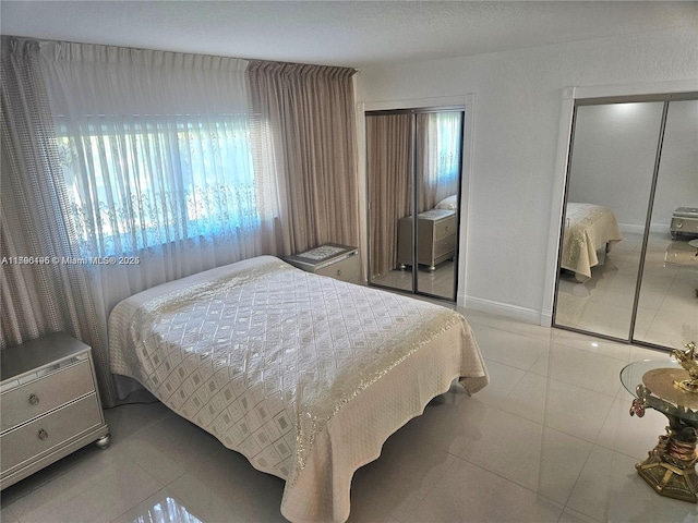 tiled bedroom featuring two closets