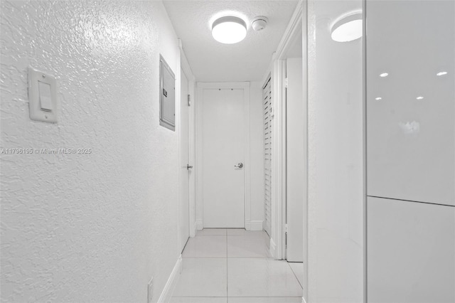 301 NE 14th Ave Unit 207, Hallandale Beach, FL 33009 - corridor with a textured wall, light tile patterned floors, baseboards, electric panel, and a textured ceiling