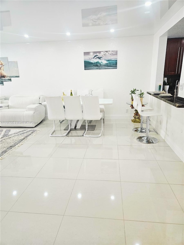 living area featuring baseboards, recessed lighting, and tile patterned floors