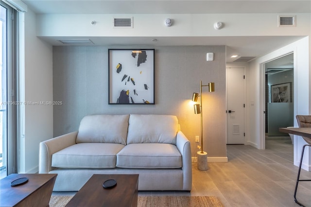 living area with baseboards and visible vents