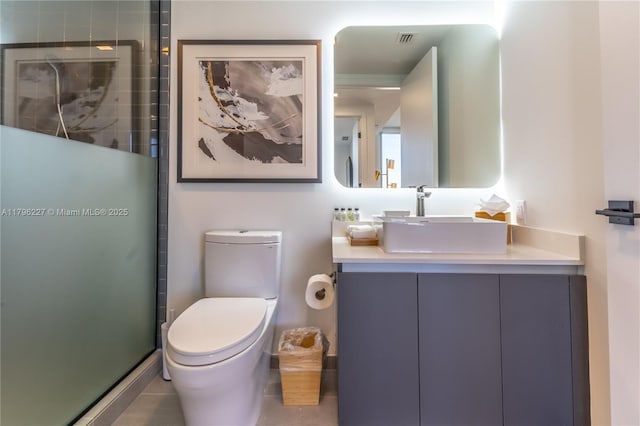 full bathroom featuring vanity, toilet, visible vents, and a stall shower