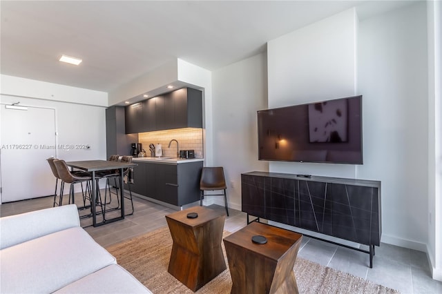 living room featuring baseboards and light tile patterned floors