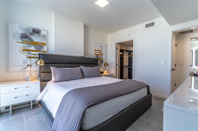 bedroom featuring visible vents, tile patterned flooring, and a spacious closet