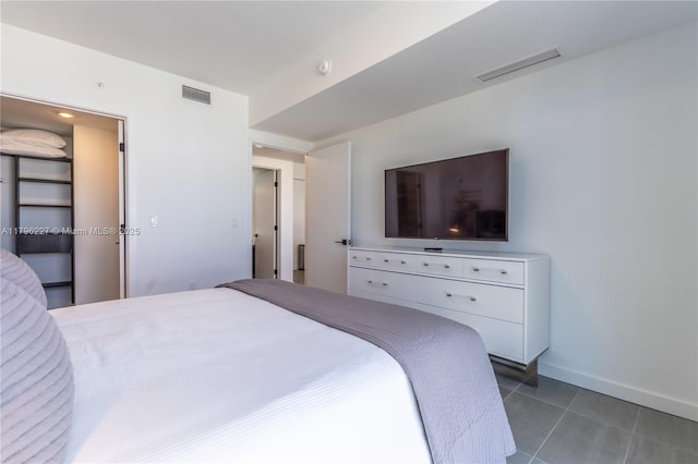 bedroom with dark tile patterned flooring, baseboards, and visible vents