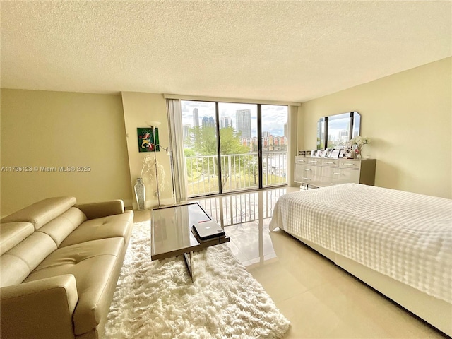 carpeted bedroom featuring a textured ceiling and expansive windows