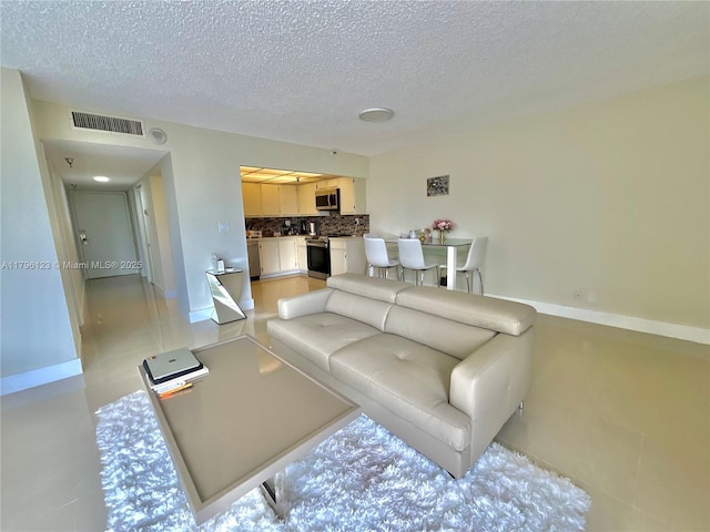 living area featuring a textured ceiling and visible vents