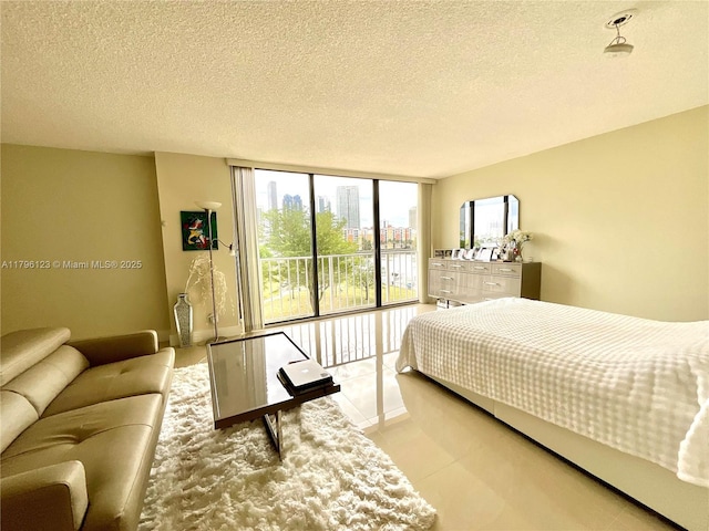 bedroom with a textured ceiling, multiple windows, and a wall of windows