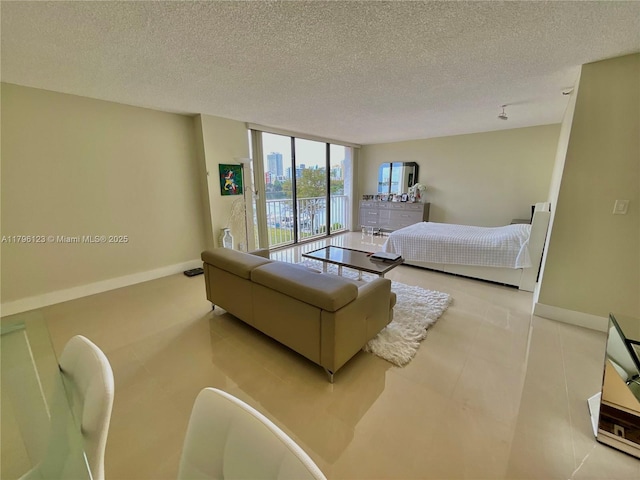 bedroom with expansive windows, a textured ceiling, and baseboards