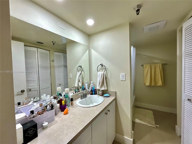 full bath featuring a closet, shower / tub combo with curtain, visible vents, vanity, and baseboards