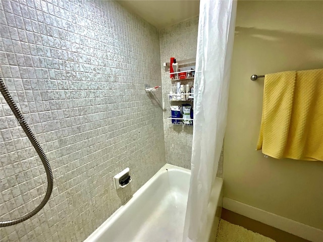 full bath featuring baseboards and shower / bath combo