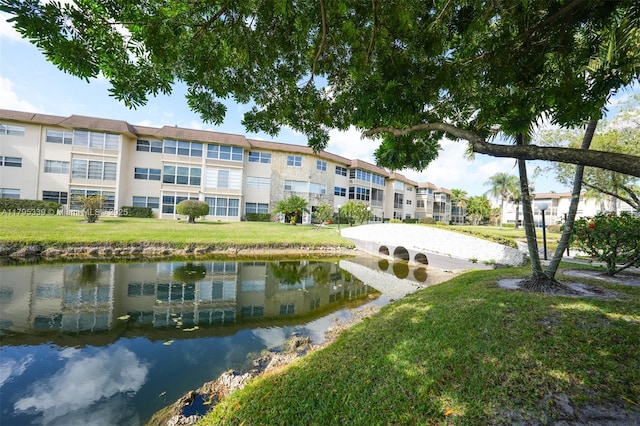 surrounding community with a lawn and a water view
