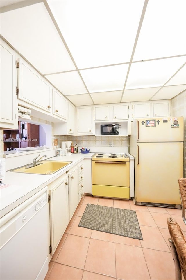 kitchen featuring light tile patterned flooring, white appliances, light countertops, white cabinetry, and a sink