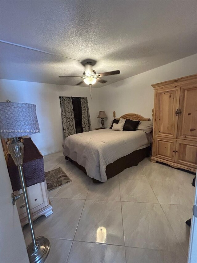 850 SW 133rd Ter Unit 312B, Pembroke Pines, FL 33027 - bedroom featuring light tile patterned floors, a ceiling fan, and a textured ceiling