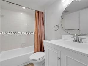 full bathroom with vanity, shower / tub combo, and toilet
