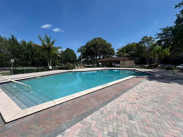 850 SW 133rd Ter Unit 312B, Pembroke Pines, FL 33027 - community pool featuring a patio area and view of wooded area