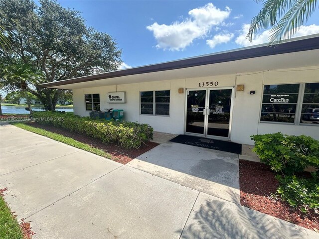 850 SW 133rd Ter Unit 312B, Pembroke Pines, FL 33027 - view of exterior entry featuring stucco siding and a water view