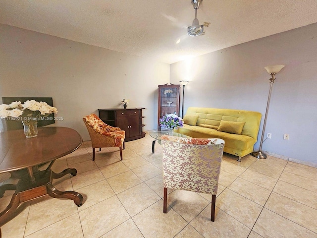 living area with a textured ceiling and light tile patterned flooring