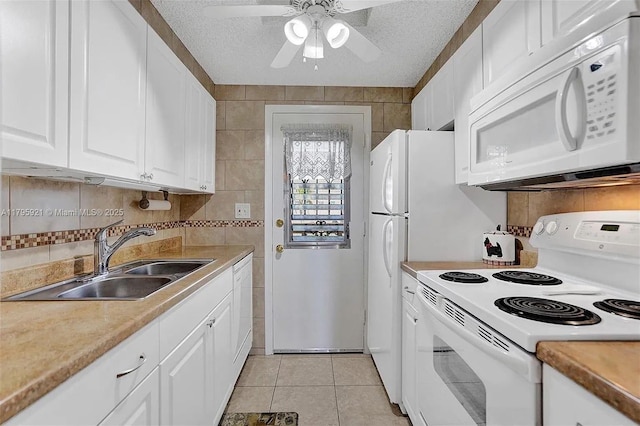 kitchen featuring white cabinets, ceiling fan, a sink, white appliances, and light tile patterned floors