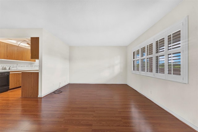 unfurnished living room with baseboards and wood finished floors