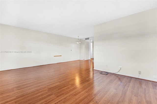 spare room with wood finished floors and visible vents