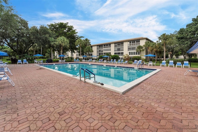 community pool featuring a patio and fence