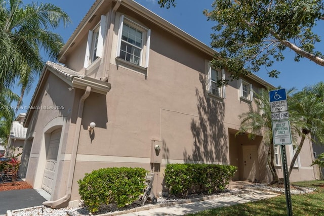 view of side of property with a garage and stucco siding