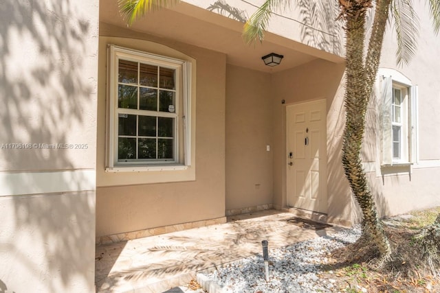 view of exterior entry featuring stucco siding