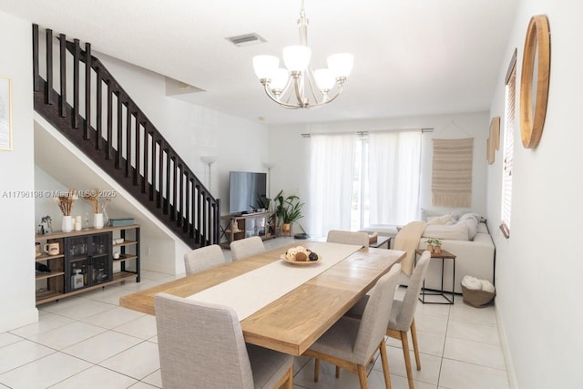 dining room featuring visible vents, stairs, light tile patterned flooring, and a chandelier
