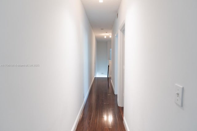hall with baseboards and dark wood finished floors